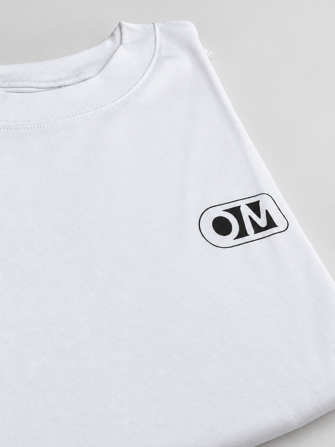 Collar and OM logo detail on the OPTIMOOD white unisex T-shirt.