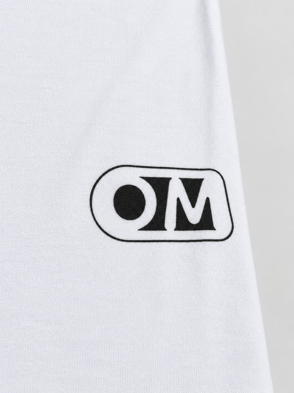 Close-up of the OM print and fabric texture on the OPTIMOOD white unisex T-shirt.